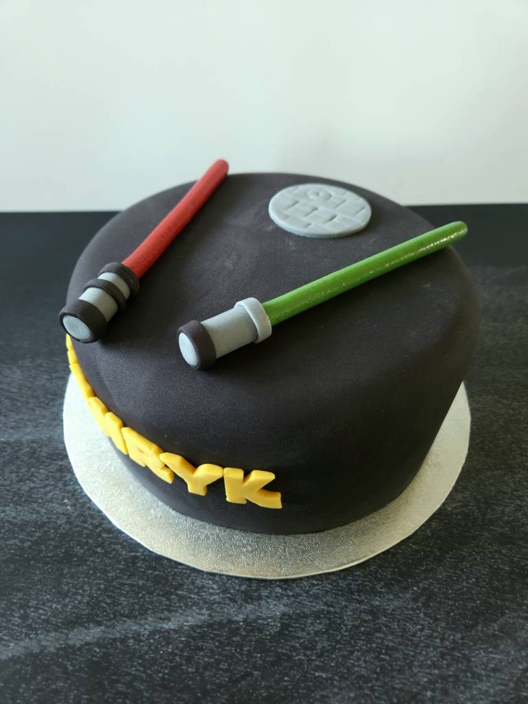 Geburtstagstorte im Star-Wars-Stil mit schwarzer Raumdecke und Lichtschwertern aus Modelliermasse